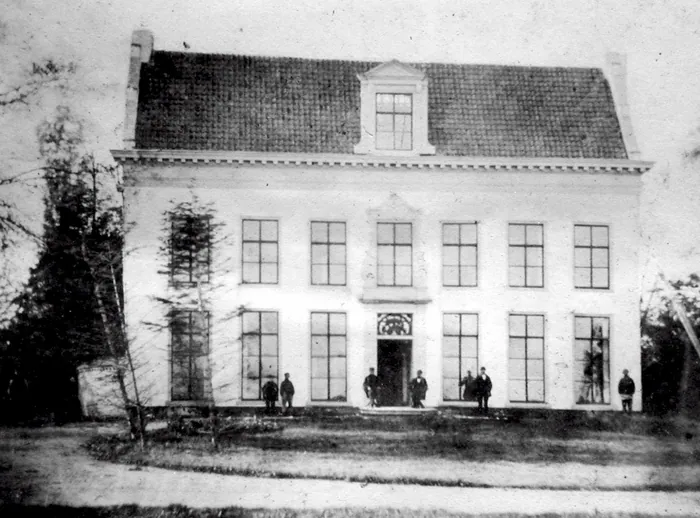 Kingma State midden negentiende eeuw, foto van een onbekende fotograaf; zeven personen voor de gevel. Reproductie met rechtgezet perspectief: op de reproductie liepen de muren naar boven toe naar elkaar toe.